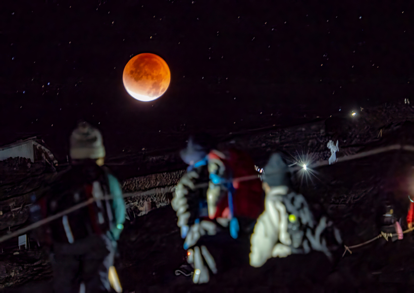 登山者と共に見上げた赤銅の月